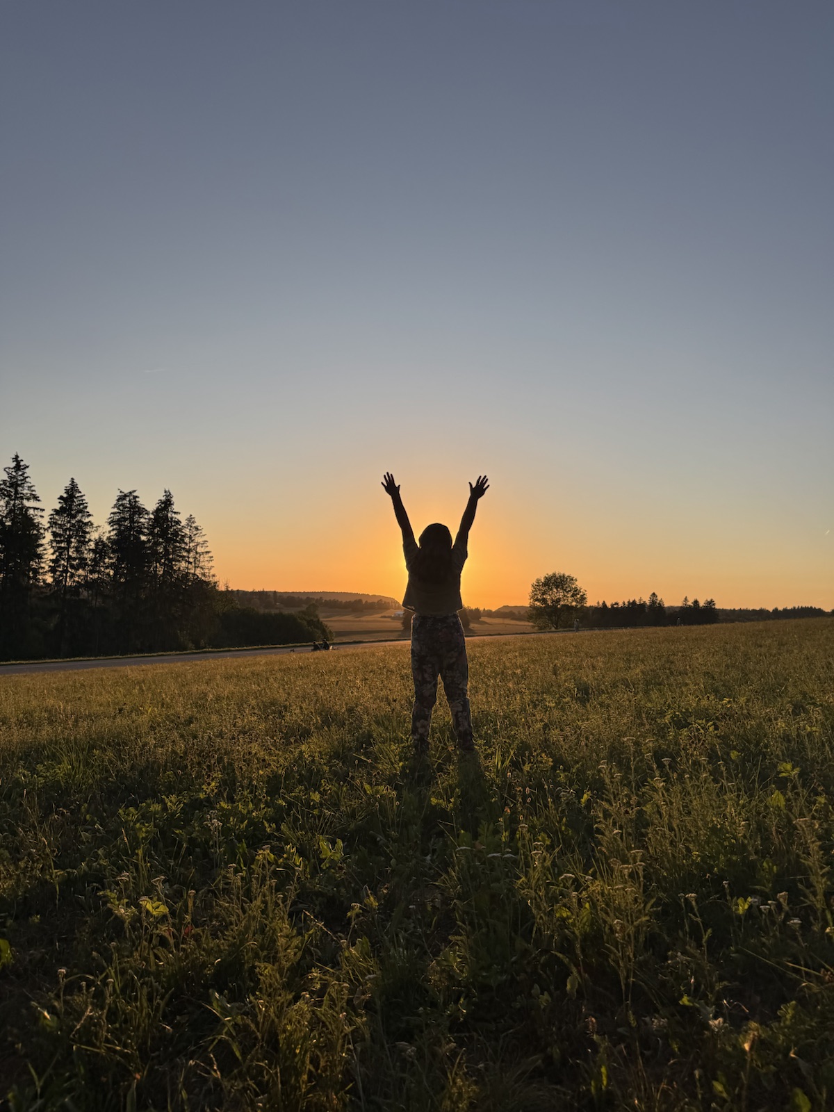 Mathilde with arms raised at sunset